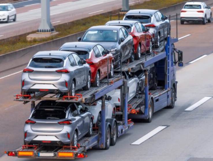 Transportation of new cars on a trailer with a truck for delivery to dealers