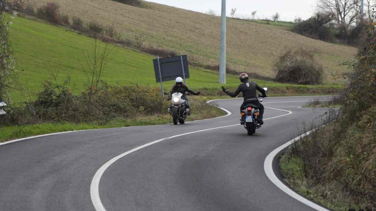 Due motociclisti mentre si salutano